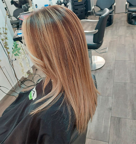 Modelo com cabelo saudável e bem tratado após serviço de coloração no salão Paula Silva Cabeleireiros, mostrando mechas suaves e brilho natural.